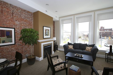 a living room with a brick wall and a couch and a table